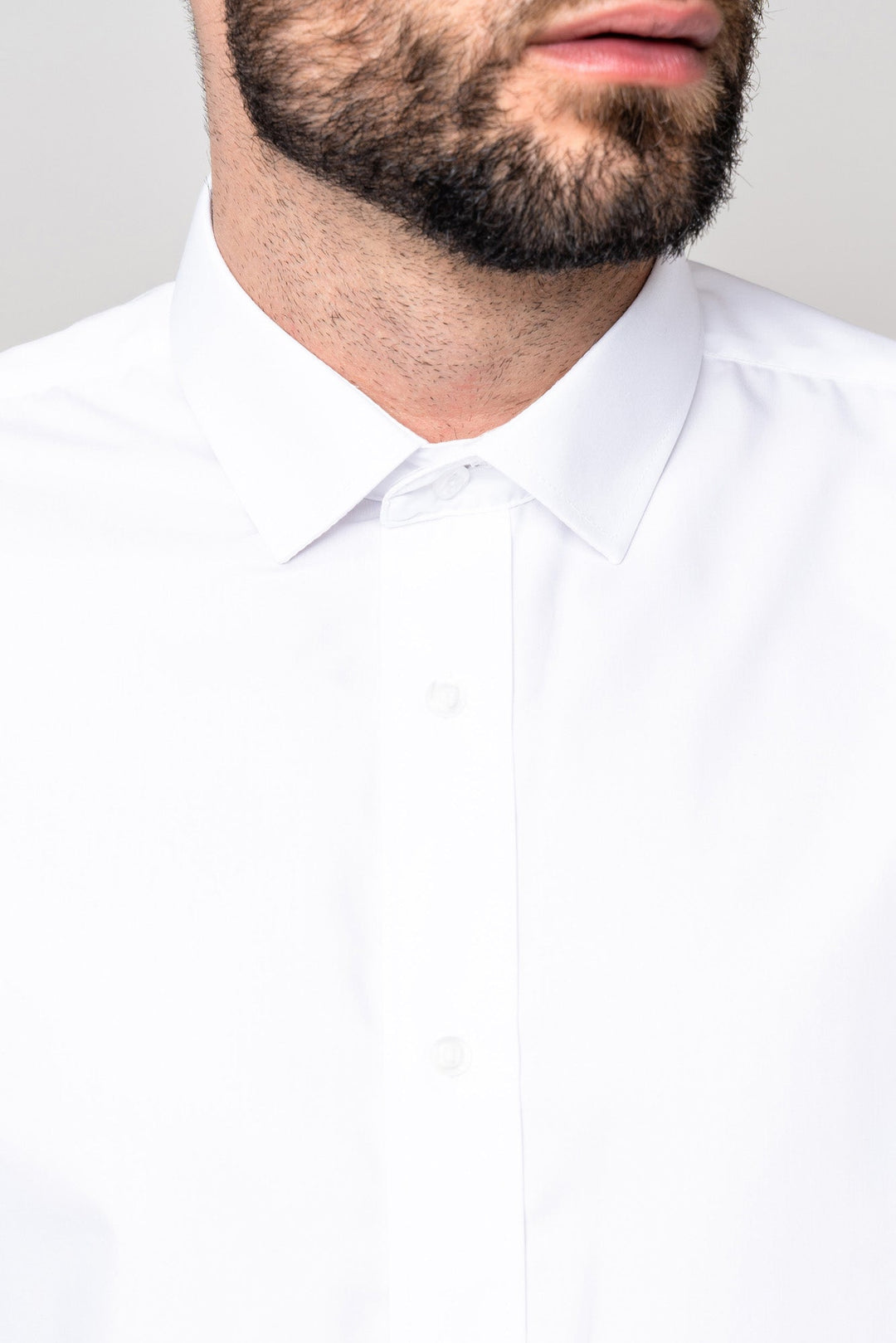 A close-up of a man wearing the Marc Darcy CARTER White Long Sleeve Shirt with a spread collar. Only his lower face with a neatly trimmed beard and mustache is visible; his eyes and forehead are out of the frame.